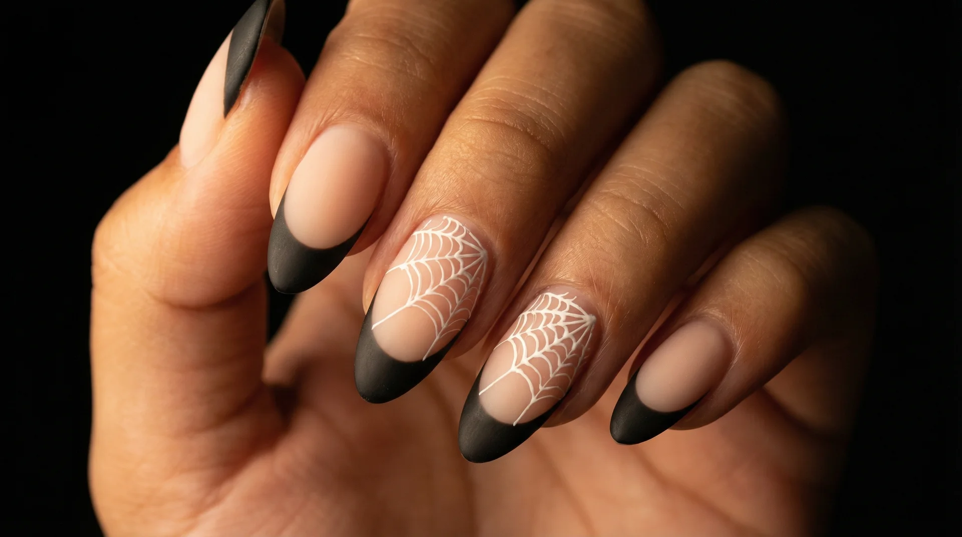 Almond nails with black french tip and delicate white hand-painted spider web accent nails
