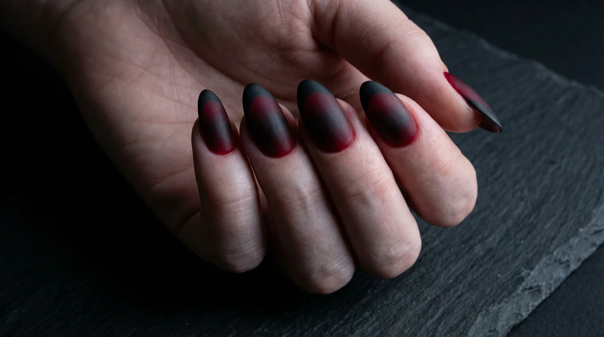 Almond nails with crimson to black gradient base blending into matte black french tip