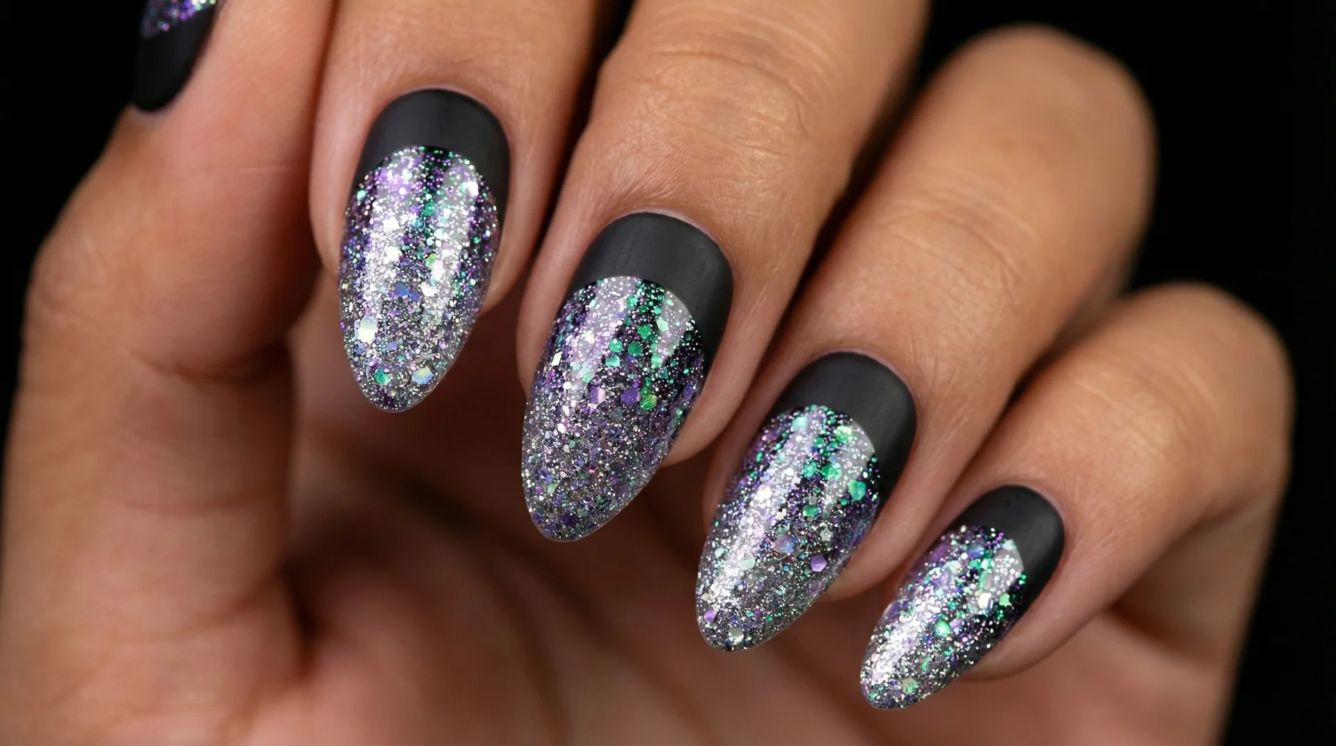 Almond nails with holographic glitter gradient base and clean matte black french tip