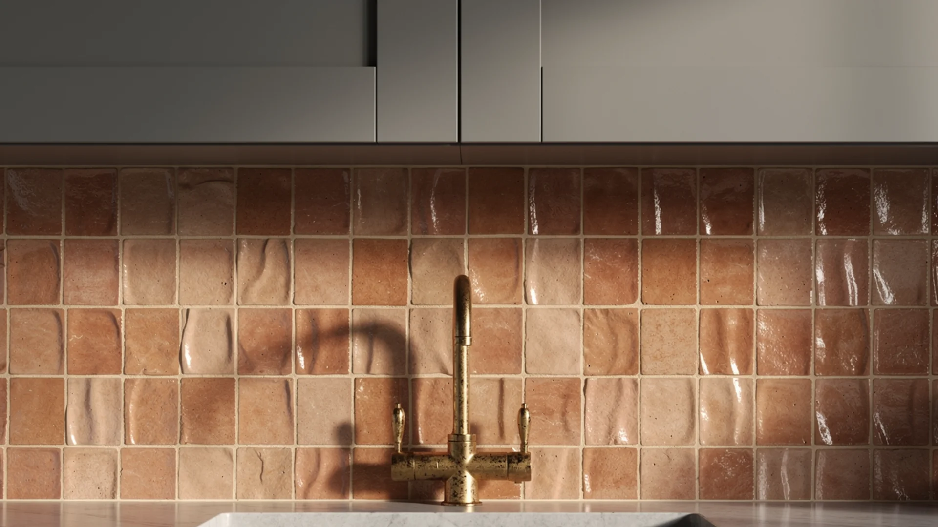 Grey kitchen with handmade terracotta zellige backsplash, warm ivory grout and aged brass faucet