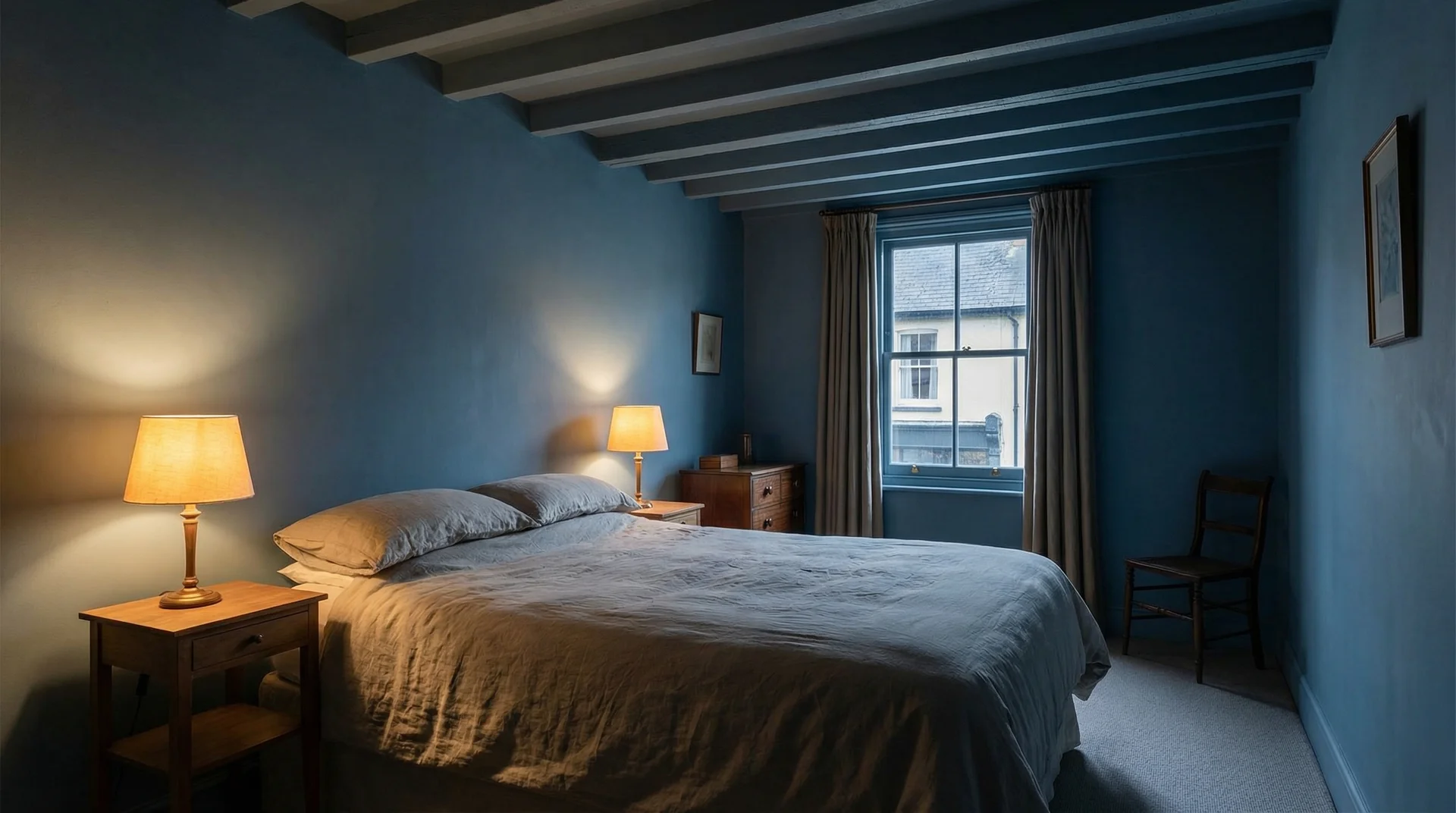 Low-ceiling Victorian bedroom painted entirely in dusty blue on walls and ceiling, creating an illusion of height