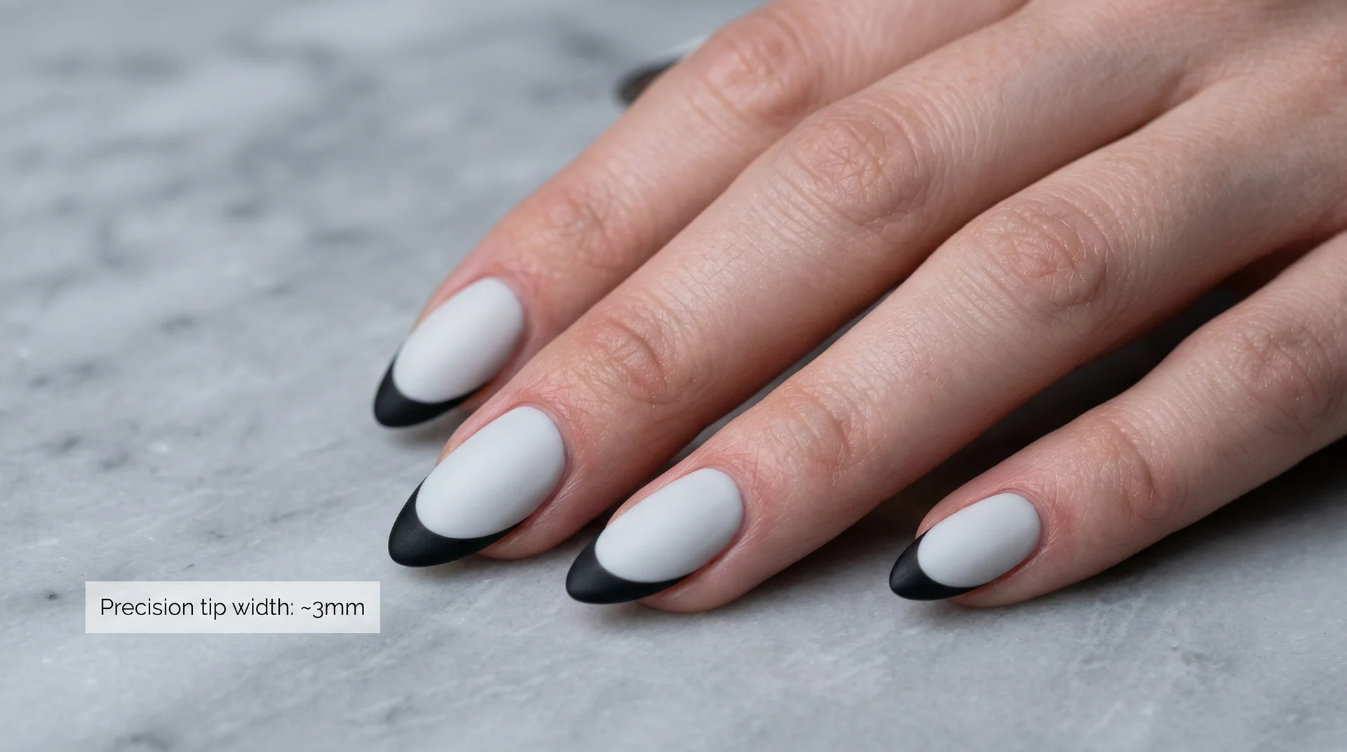 Succession-inspired minimalist almond nails with sharp black french tip on cool ivory base