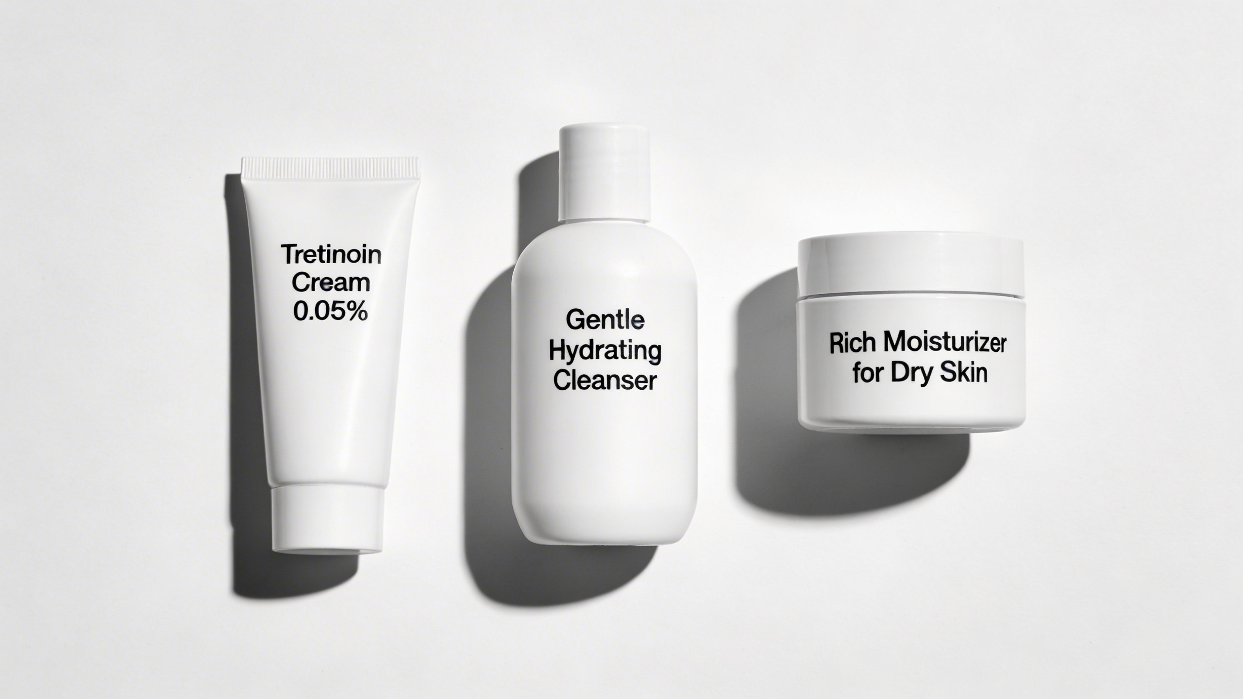 Tretinoin tube, gentle cleanser, and moisturizer flat lay showing the essential products needed before starting tretinoin