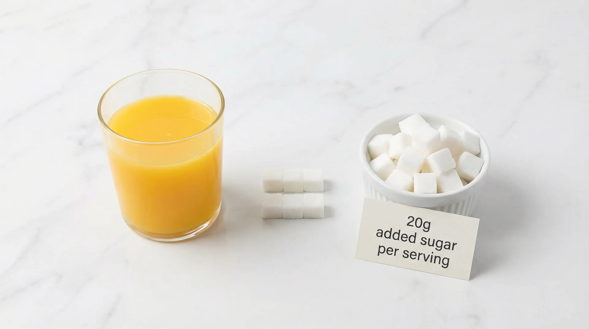 8-ounce glass of orange juice next to a bowl showing its 20 grams of sugar content per serving