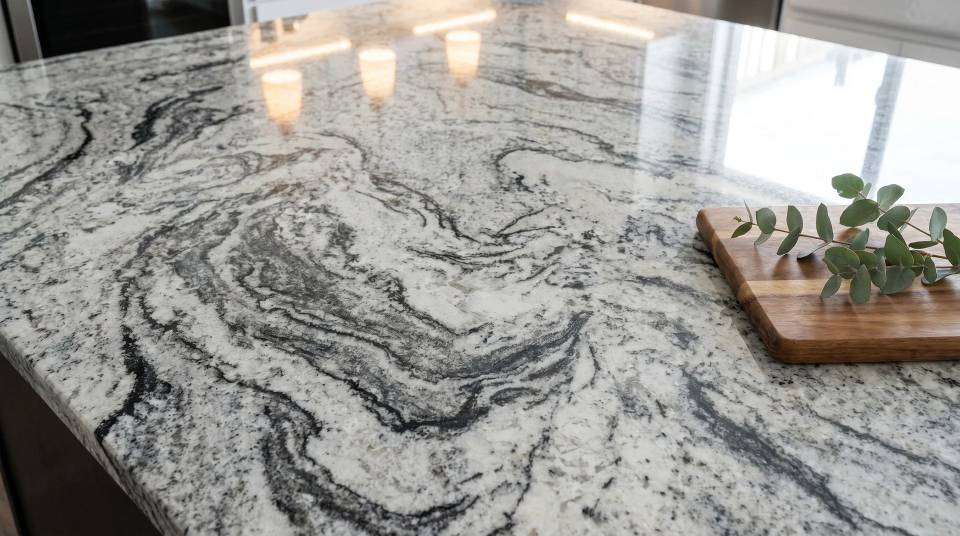 Alaska White granite countertop close-up showing dramatic swirling gray and black veining on a bright white base