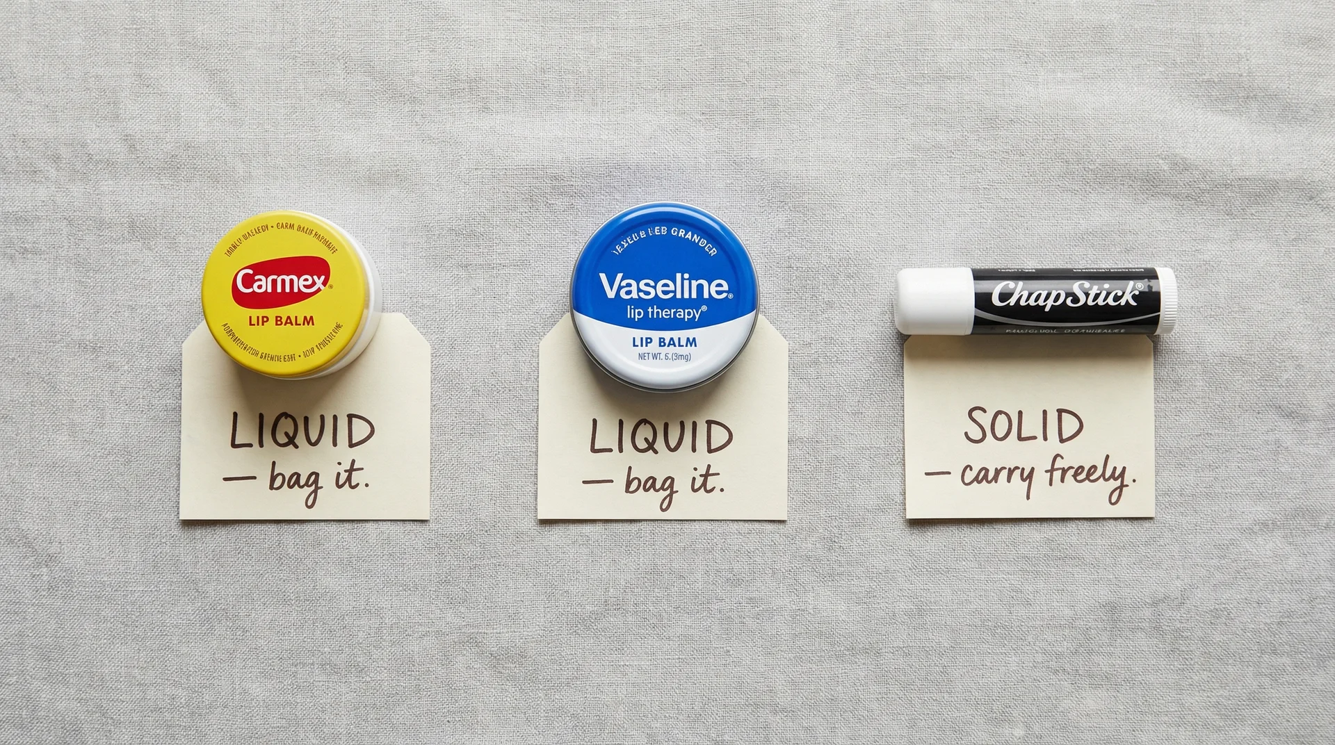 Carmex pot and Vaseline tin labelled as TSA liquids next to ChapStick stick labelled as TSA solid