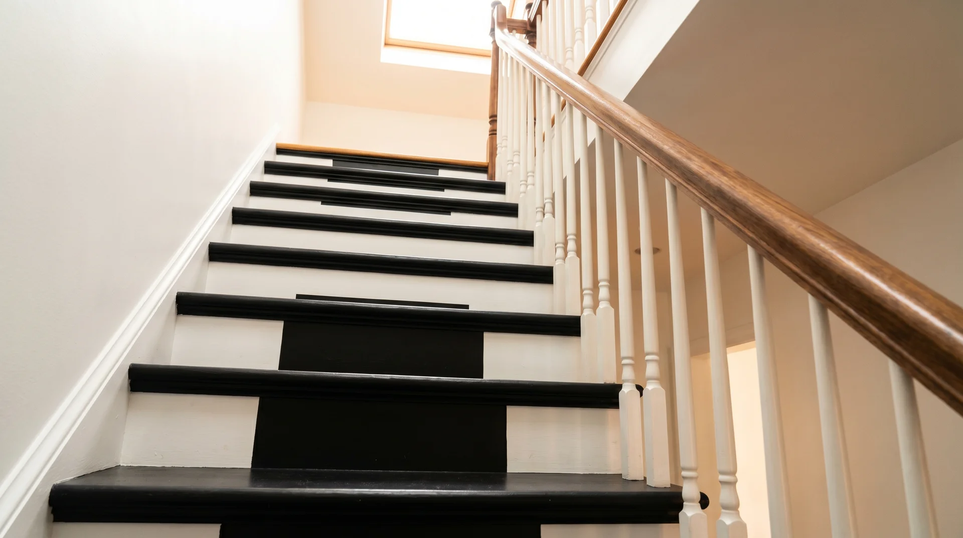 Close-up of a classic staircase with matte black painted treads and crisp white risers showing sharp high-contrast lines