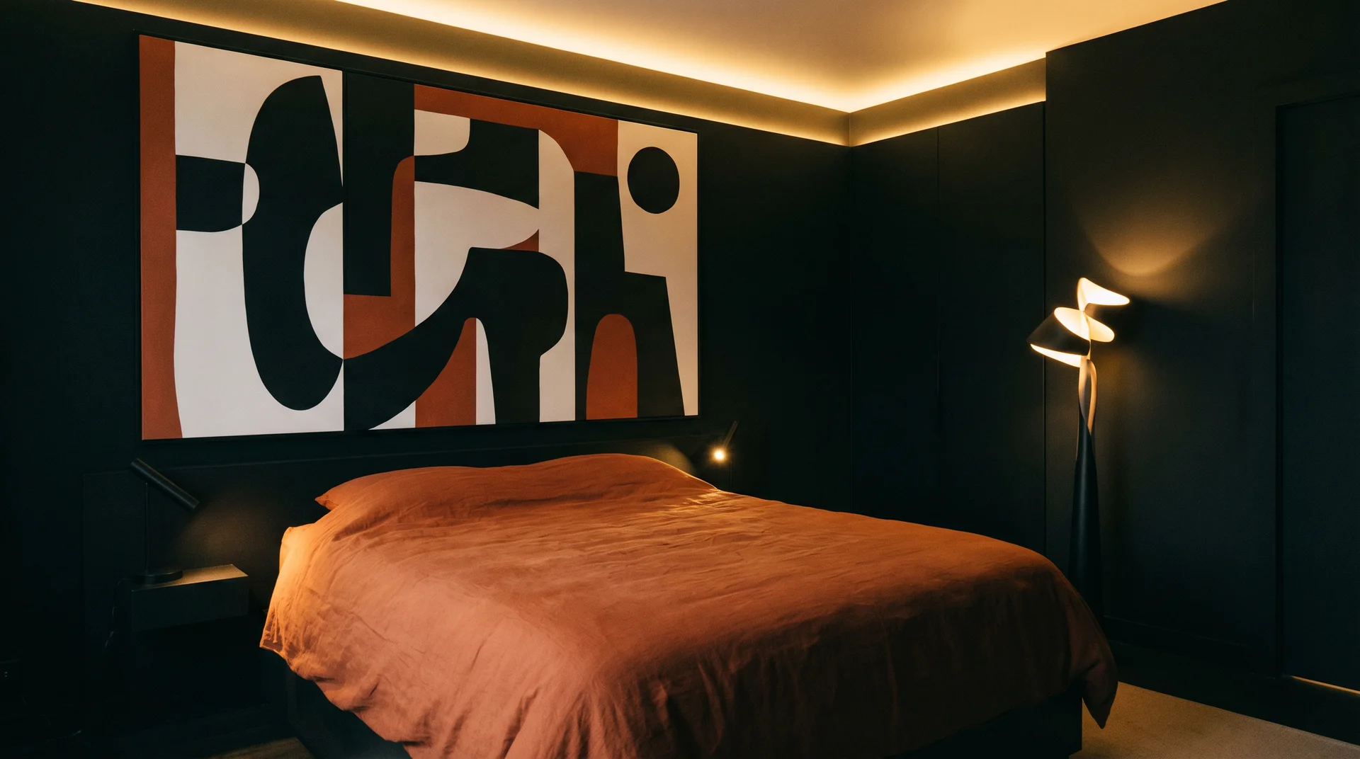 Near-black bedroom walls with a burnt orange duvet and a graphic black white and orange artwork above the bed
