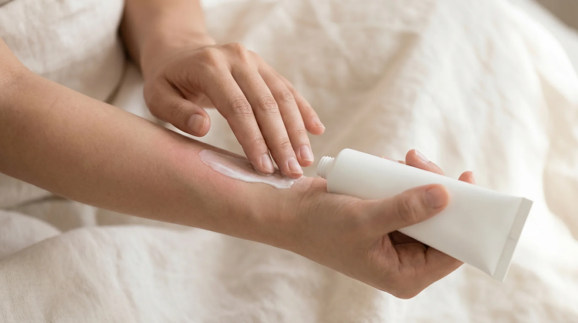 Person applying fragrance-free moisturizer to sun-exposed skin as part of post-burn aftercare
