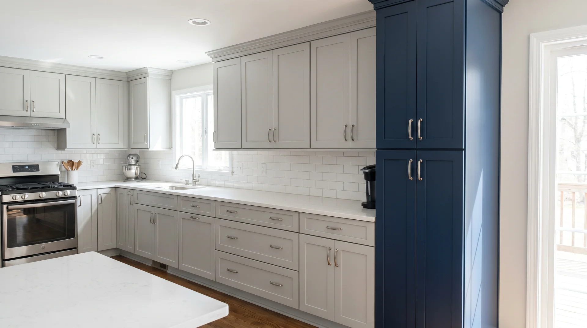 Gray kitchen with single full-height navy pantry cabinet as a focal point showing two tone palette with minimal commitment
