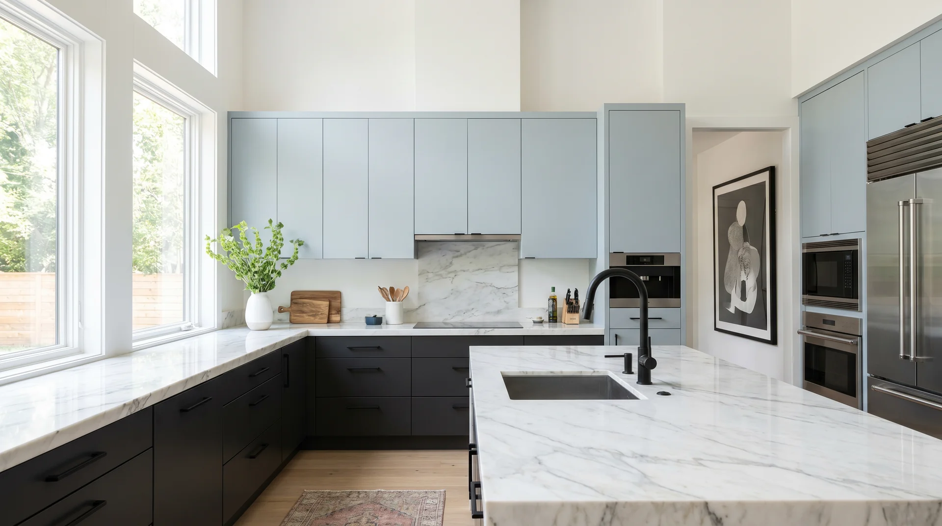 High contrast two tone kitchen with Iron Ore dark lower cabinets and light Stardew blue-gray uppers, white marble countertop 