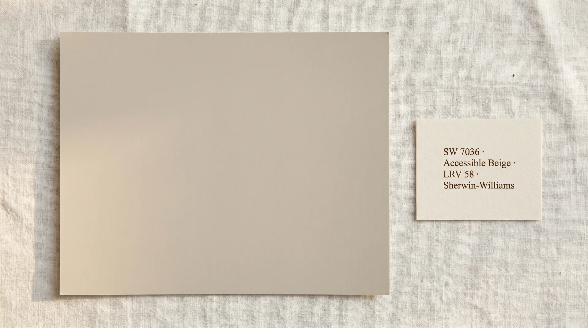 Sherwin-Williams Accessible Beige SW 7036 paint swatch with LRV 58 label on a natural linen surface
