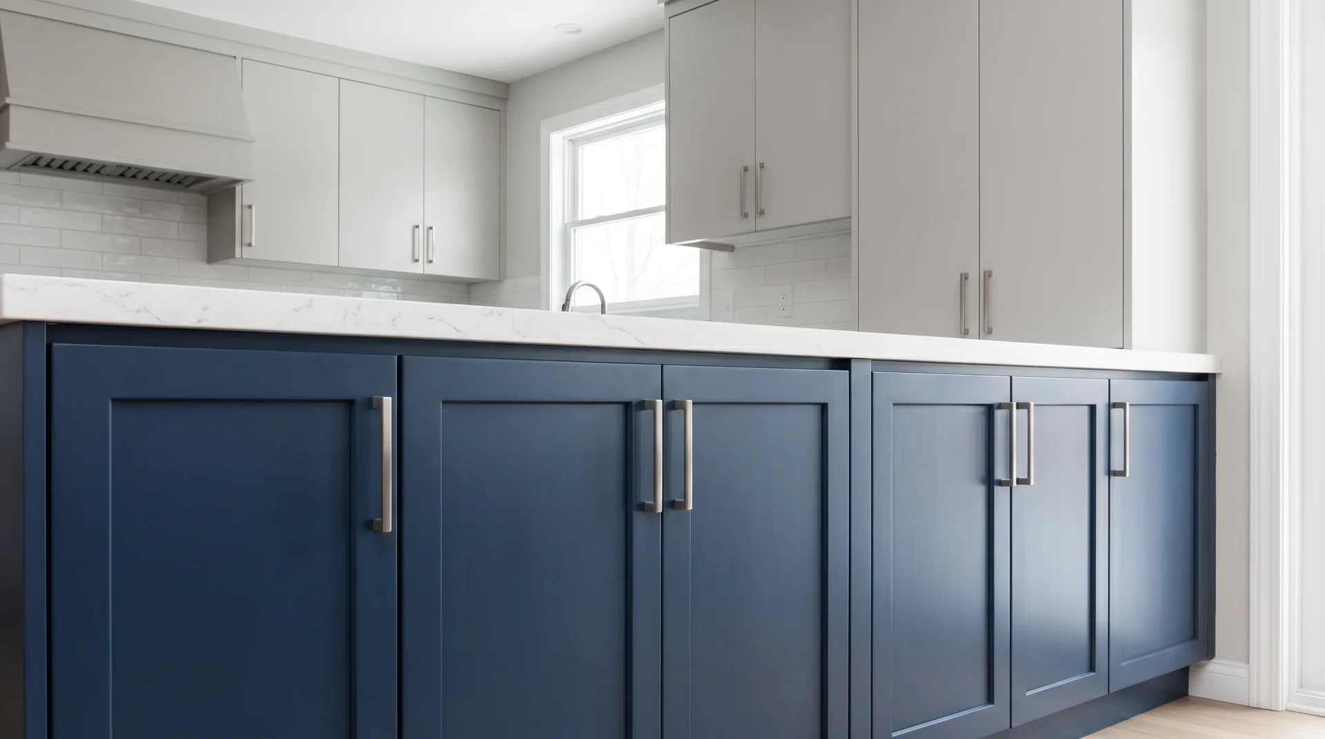 Two tone kitchen combining navy Shaker lower cabinet doors and gray flat-panel upper cabinet doors for dual contrast in color and style